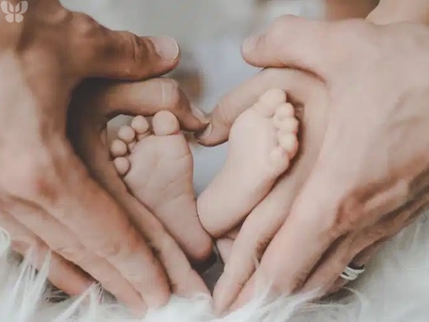 Pieds de bebe entre les mains des parents.jpg